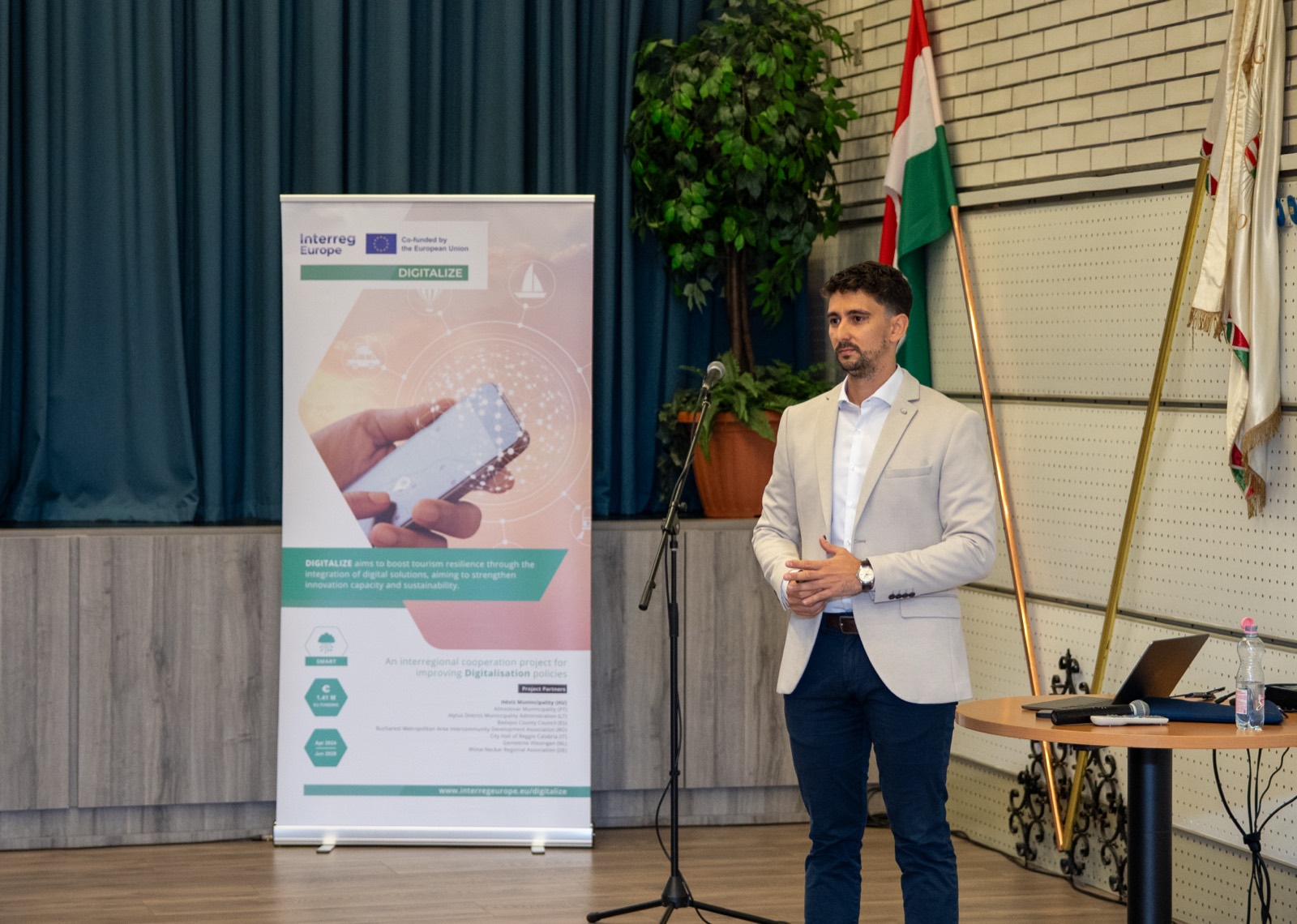 01: The “Digital revolution in tourism” title slide on the screen on the event stage (Hévíz, 2025). 02–06: Adam Schmutz speaking about the digitalization of tourism, next to the DIGITALIZE (Interreg Europe) project banner.