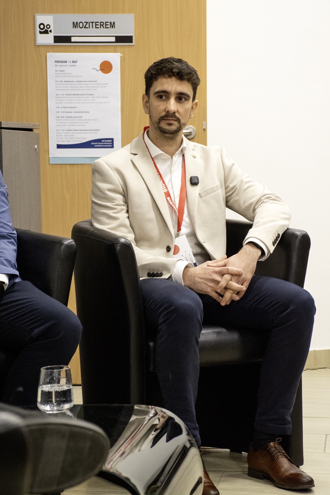 Adam Schmutz on the panel of the KULTKIKÖTŐ conference (Balatonföldvár, 2026) | Adam Schmutz gesturing while speaking on the KULTKIKÖTŐ conference panel | Adam Schmutz and Botond Boros (Visit Hungary) discussing tourism innovation at the KULTKIKÖTŐ conference | Botond Boros, Visit Hungary expert, on the panel at the KULTKIKÖTŐ conference | The audience of the KULTKIKÖTŐ conference during the panel | A question from the audience at the KULTKIKÖTŐ conference panel | KULTKIKÖTŐ – In the Same Boat Cultural Tourism Conference 2026 – conference badges